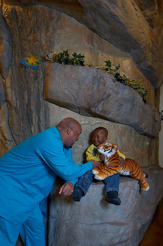 Dr. Gillespie with his son while his son holds a tiger stuffed animal