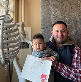 A man and a child holding a certificate from lil teeth dentistry