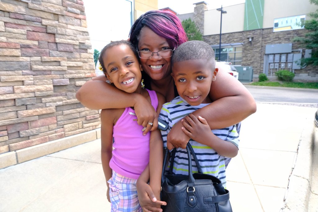 A mother and 2 children smiling